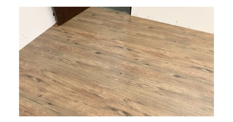 a side of the room where there is door, flooring is completely installed with no seams